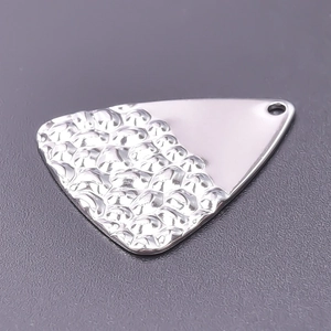 Macro shot of silver triangle pendant with hammered texture and mirror polished finish