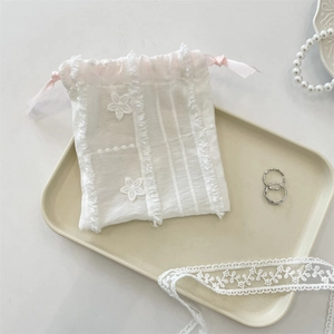 Detailed view of lace drawstring pouch with floral embroidery and pink silk ribbon ties