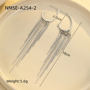 Detailed view of silver stainless steel tassel earrings with zircon on a beige tray