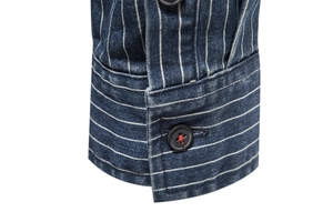 Macro view of blue denim cuff with white stripes and red stitching on a black button