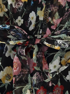 Detailed close-up of floral chiffon dress featuring a delicate waist tie bow design