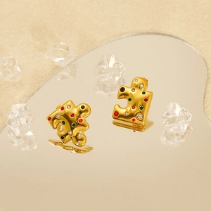 18K gold plated puzzle shaped earrings with colorful crystals on a reflective surface