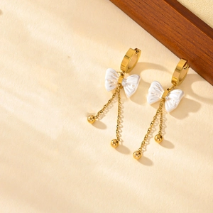 Elegant gold butterfly tassel earrings with white pearls and minimalist shadow lighting