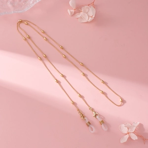 Detail view of gold bead eyewear chain with lobster clasps and silicone loops on pink floral