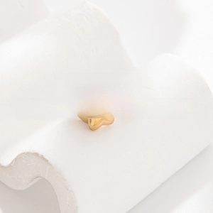 Macro shot of gold-plated stainless steel butterfly and star open ring on white pedestal