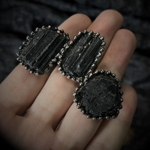 Macro view of irregular black tourmaline stone with beaded silver plating on ring band