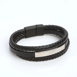 Detail of multi-layer black braided leather bracelet with silver metal plate and magnetic clasp