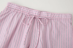 Détail d'un short à rayures roses et grises avec taille élastique et cordon de serrage