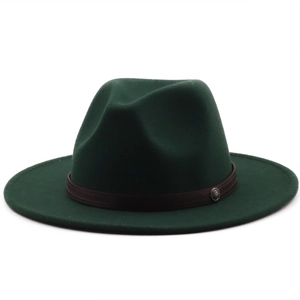 Detail of dark green wool felt jazz hat featuring a brown ribbon and silver metal emblem