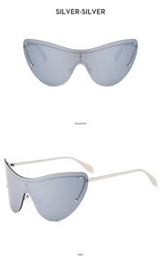 Macro view of silver rimless cat-eye sunglasses with metal studs and futuristic temples