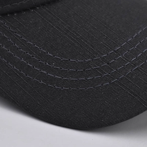 Detailed close-up of a black cotton baseball cap showing quality twill texture and stitching