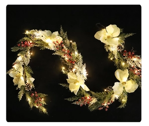Détail de guirlande de Noël avec magnolias blancs, pommes de pin, baies et LED chaudes