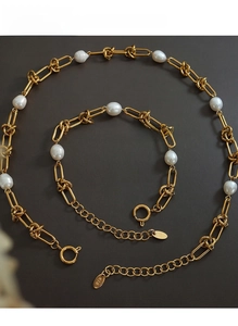 Macro shot of 18K gold plated chain and freshwater pearl details on jewelry set