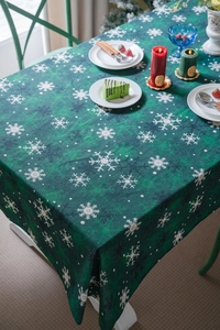 Détail de nappe de Noël verte avec flocons blancs et décor de table festif élégant