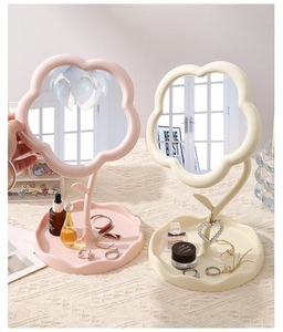Detail of flower-shaped vanity mirror with jewelry tray in pink and cream matte finish