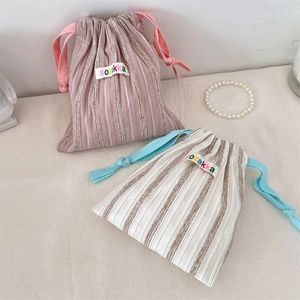 Close-up of striped drawstring storage pouches with cotton-linen texture and sozakka labels