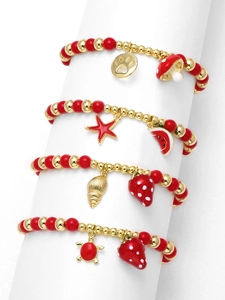 Macro view of four red and gold beaded bracelets with enamel fruit and mushroom charms