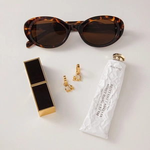 Detail of golden elephant earrings with rhinestones alongside elegant fashion accessories