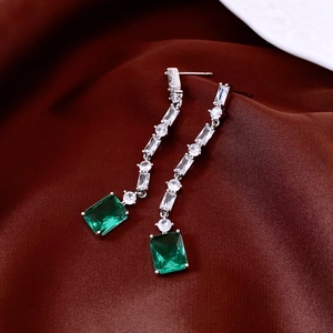Detail of silver tassel earrings with rectangle emerald green crystal on silk
