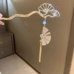 Détail d'une épingle à cheveux fleur de muguet dorée avec éventail et longues franges