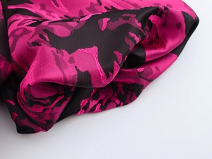 Close-up detail of vintage floral jacquard fabric with magenta flowers and premium texture