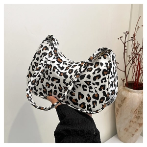 Detailed view of fashionable leopard print shoulder bag featuring unique curved design