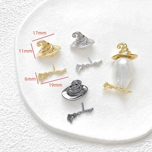 Macro detail of gold and silver witch hat charms with size measurements for DIY jewelry