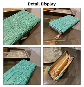 Detail of teal long zipper wallet showing crocodile texture and multi-layer inner pockets