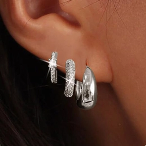 Detailed view of silver-tone hoop earring set with cubic zirconia worn on ear lobe