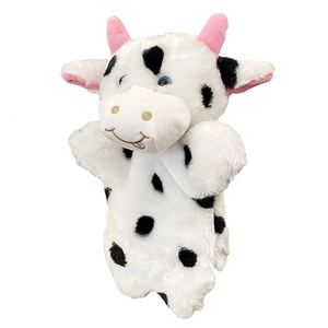 Marionnette vache en peluche noir et blanc aux yeux bleus pour raconter des histoires