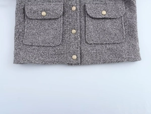 Détail du manteau en polaire grise avec boutons dorés en métal et grandes poches à rabat