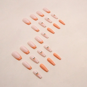 Long French press-on nails featuring minimalist peach and orange heart art designs