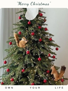 Close-up of a realistic brown flocked squirrel ornament hanging on a festive Christmas tree