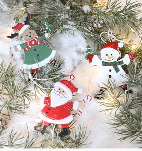 Detail of metal Christmas ornaments with Santa, snowman and deer on festive snow background