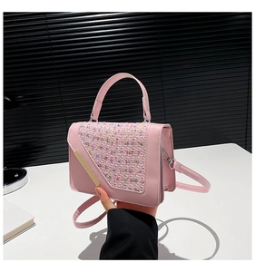 Gros plan d'un sac à main rose en cuir PU avec rabat en tweed et barre métallique dorée