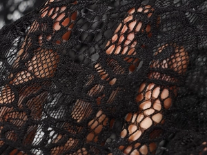 Dettagli in pizzo nero che mostrano intricati motivi floreali e una trama trasparente