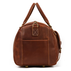 Macro side view of vintage brown crazy horse leather travel bag with reinforced handles