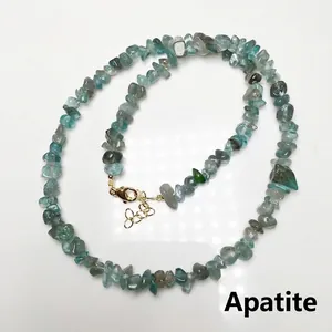 Macro detail of natural apatite stone chips necklace with gold-plated lobster clasp