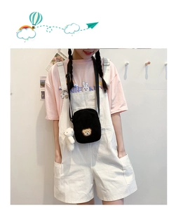 Detail of black corduroy mini crossbody bag with cute bear embroidery and plush charm