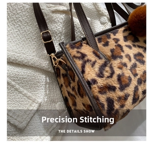 Detailed close-up of side stitching and gold-tone metal buckle on leopard print plush bag