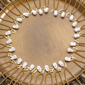Baroque pearl initial necklace with 26 gold letters on a vintage tray display