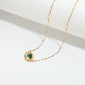 Minimalist gold necklace with a green Devil's Eye pendant and sparkling sunburst crystals