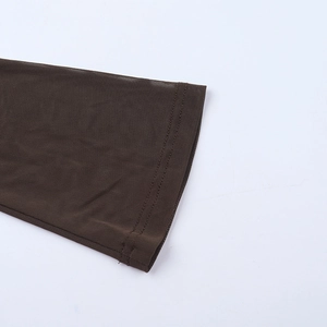 Détail d'une manche en maille marron foncé avec couture double aiguille et tissu transparent