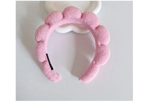 Detail shot of a soft pink bubble headband on a white tray with plush texture