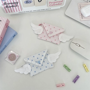 Pastel envelope coin purses with plush wings and star patterns on desk