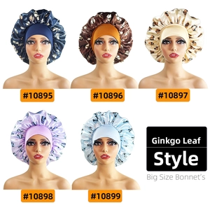 Detail view of large satin sleep bonnets with ginkgo leaf patterns in five colors