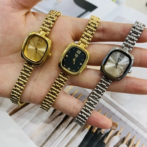 Close-up of three luxury square dial watches in gold and silver with metal strap