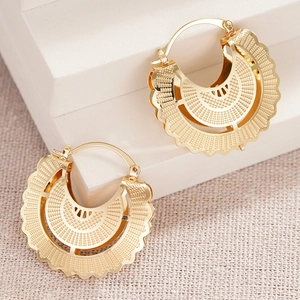 Detail view of gold hollow textured hoop earrings with intricate bohemian mesh pattern