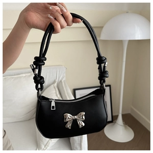 Minimalist black leather underarm bag featuring a silver bow metal decoration and knotted strap