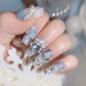 Sparkly light blue snowflake press-on nails with rhinestones and large star gems